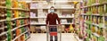 Man in protective mask shopping in supermarket pushing trolley during epidemic