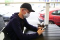 Man in protective mask sitting in empty cafe