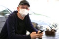 Man in protective mask sitting in empty cafe