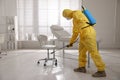 Man in protective suit sanitizing doctor`s office. Medical disinfection
