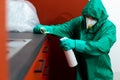 Man in protective suit spraying chemicals on kitchen cabinetry Royalty Free Stock Photo