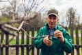 Man pruning tree with clippers. Male farmer cuts branches in autumn garden with pruning shears or secateurs Royalty Free Stock Photo