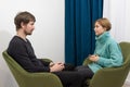 A man in a psychologists office for a consultation. A female psychologist advises a man during a psychological therapy session. Royalty Free Stock Photo