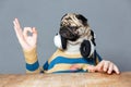 Man with pug dog head in headphones showing ok gesture Royalty Free Stock Photo