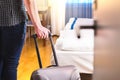 Man Pulling Suitcase And Entering Hotel Room.