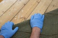 Man pulling up and removing carpet underlay from a wooden floor. Royalty Free Stock Photo