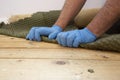 Man pulling up and removing carpet underlay from a wooden floor. Royalty Free Stock Photo