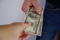 The man pulls money out of the pocket of blue jeans. Close-up view of the hands. Place for your text Royalty Free Stock Photo