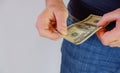 The man pulls money out of the pocket of blue jeans. Close-up view of the hands. Place for your text Royalty Free Stock Photo