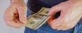 The man pulls money out of the pocket of blue jeans. Close-up view of the hands. Place for your text Royalty Free Stock Photo