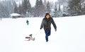 Man pulls sled in the snow, winter forest snowfall snowflakes, play fun activity Royalty Free Stock Photo