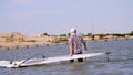 a man pulls the windsurfing board , man learns to ride on a board with a sail, windsurfing on the crystal clear water Royalty Free Stock Photo