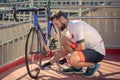 Man with pump crouched near bicycle wheel Royalty Free Stock Photo