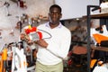 Man with pump in gardening tools store