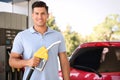 Man with fuel pump nozzle at self service gas station