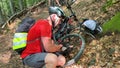 Cyclist pumping bicycle wheel outdoors.