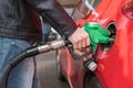 Man is pumping gas in red car in fuel station. Royalty Free Stock Photo