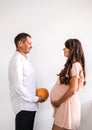 Man with pumpkin opposite a pregnant woman. Royalty Free Stock Photo