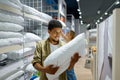 Man purchaser holding pillow in textile shop