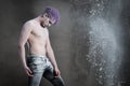 A man with purple hair with powdered  flour on a gray background Royalty Free Stock Photo
