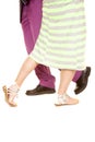 Man purple suit woman green dress walk past legs Royalty Free Stock Photo