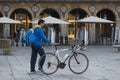 A man pushes a bicycle walking in Salamanca Spain