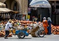 A man pushes a cart past a stall in Lahdim Square , the main square in the old city section of Meknes in Morocco.