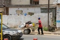 A man pushing a hand truck in a street in the city of Dakar in S