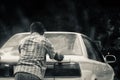 Man pushing an inactive cars on a city streets in Dhaka