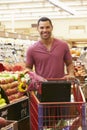 Man Pushing Trolley By Fruit Counter In Supermarket Royalty Free Stock Photo