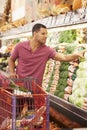 Man Pushing Trolley By Produce Counter In Supermarket Royalty Free Stock Photo
