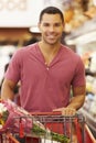 Man Pushing Trolley By Produce Counter In Supermarket Royalty Free Stock Photo