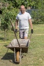 man pushing wheelbarrow. Young man pushing a wheelbarrow on the farm. Royalty Free Stock Photo