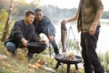 Man put big fish in cauldron for cooking Ukha soup