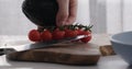man put cherry tomatoes on a branch and avocado on wood table Royalty Free Stock Photo