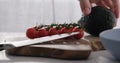 man put cherry tomatoes on a branch and avocado on wood table Royalty Free Stock Photo