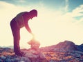 Man put the last stone intopeak of pyramid. Balanced stone pyramid on mountain summit. Royalty Free Stock Photo