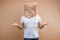 The man put a paper bag on his head, spreads his arms to the sides, despondency, depression. Isolate on yellow background, images Royalty Free Stock Photo