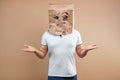 The man put a paper bag on his head, spreads his arms to the sides, despondency, depression. Isolate on yellow background, images Royalty Free Stock Photo