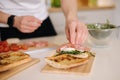 Man put slice of Italian salami on top of bruschetta. Healthy home made food Royalty Free Stock Photo