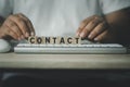 Man put wooden blocks with text contact on keyboard Royalty Free Stock Photo