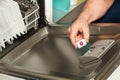 Man puting a tablet in the dishwashing machine Royalty Free Stock Photo