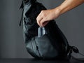 A man puts alcohol gel in a black modern backpack. Royalty Free Stock Photo