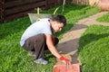 Man puts concrete tiles on the path