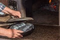 A man puts a frying pan with meat in a hot oven.