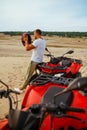 Man puts on helmet near atv in desert sands Royalty Free Stock Photo
