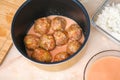 A man puts lazy cabbage rolls into multicooker bowl and pours tomato and sour cream sauce over them. Royalty Free Stock Photo
