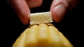 Man puts a piece of butter on sweetcorn cob. Close up. Royalty Free Stock Photo