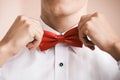 Man puts on red bow tie. Close up. Shallow depth of field.