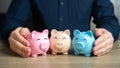 A man puts together piggy banks. Create your investment portfolio. Royalty Free Stock Photo